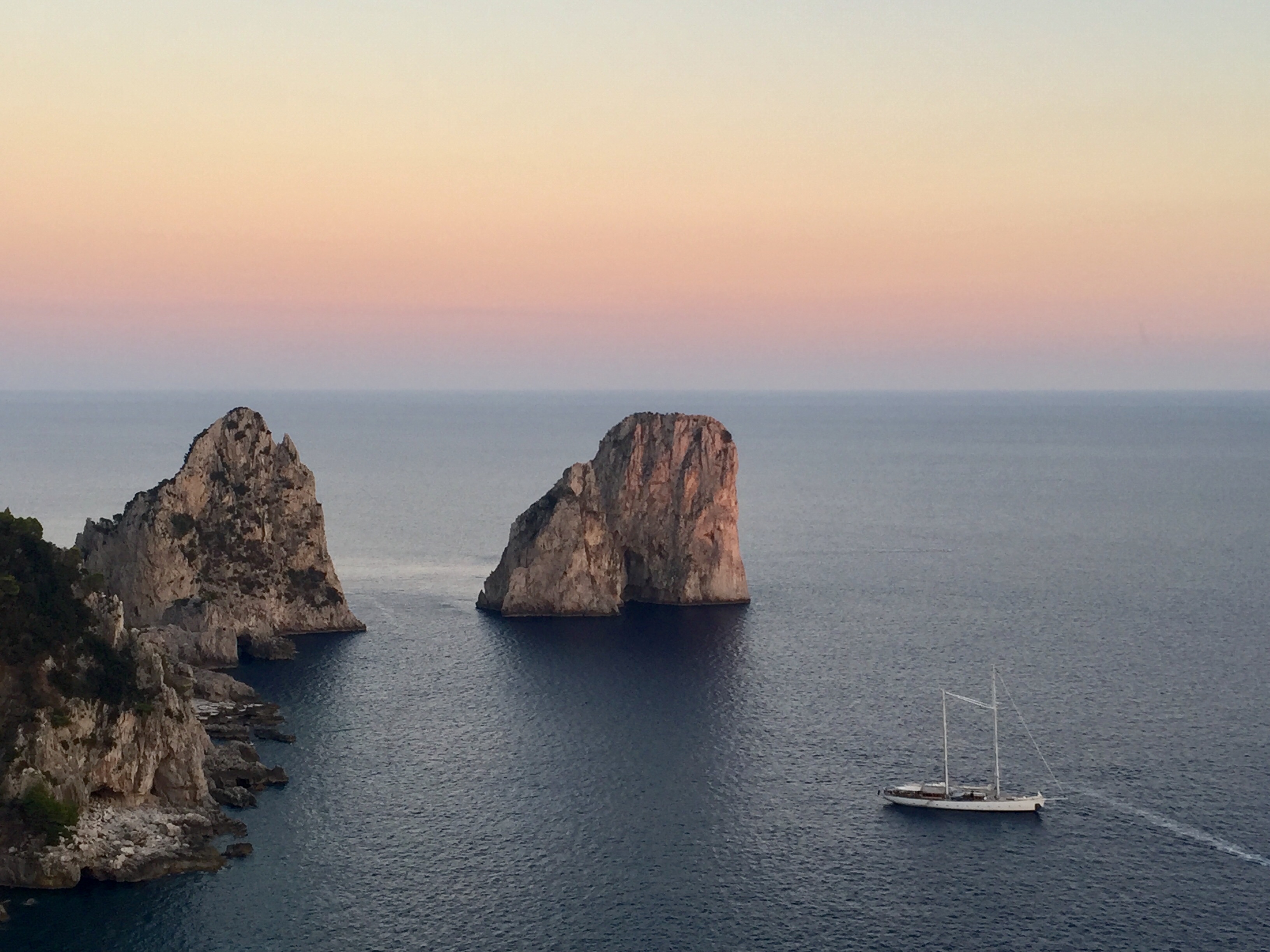 Paisaje de rocas emergiendo del mar con puesta de sol - Costa Amalfitana