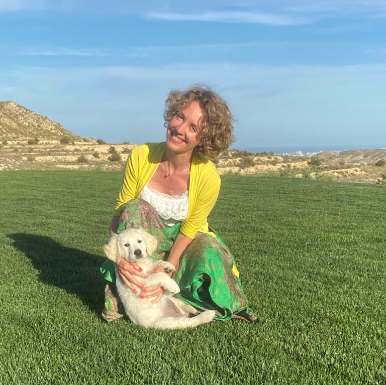 Mujer muy sonriente con cachorro de Golden al aire libre