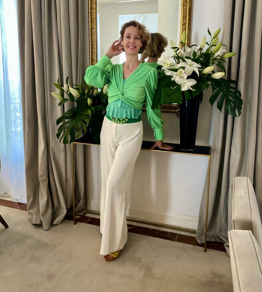 Dr. Carolina Diez Jorge International Psychologist. Vestida en blanco y verde con fondo de flores lirios 