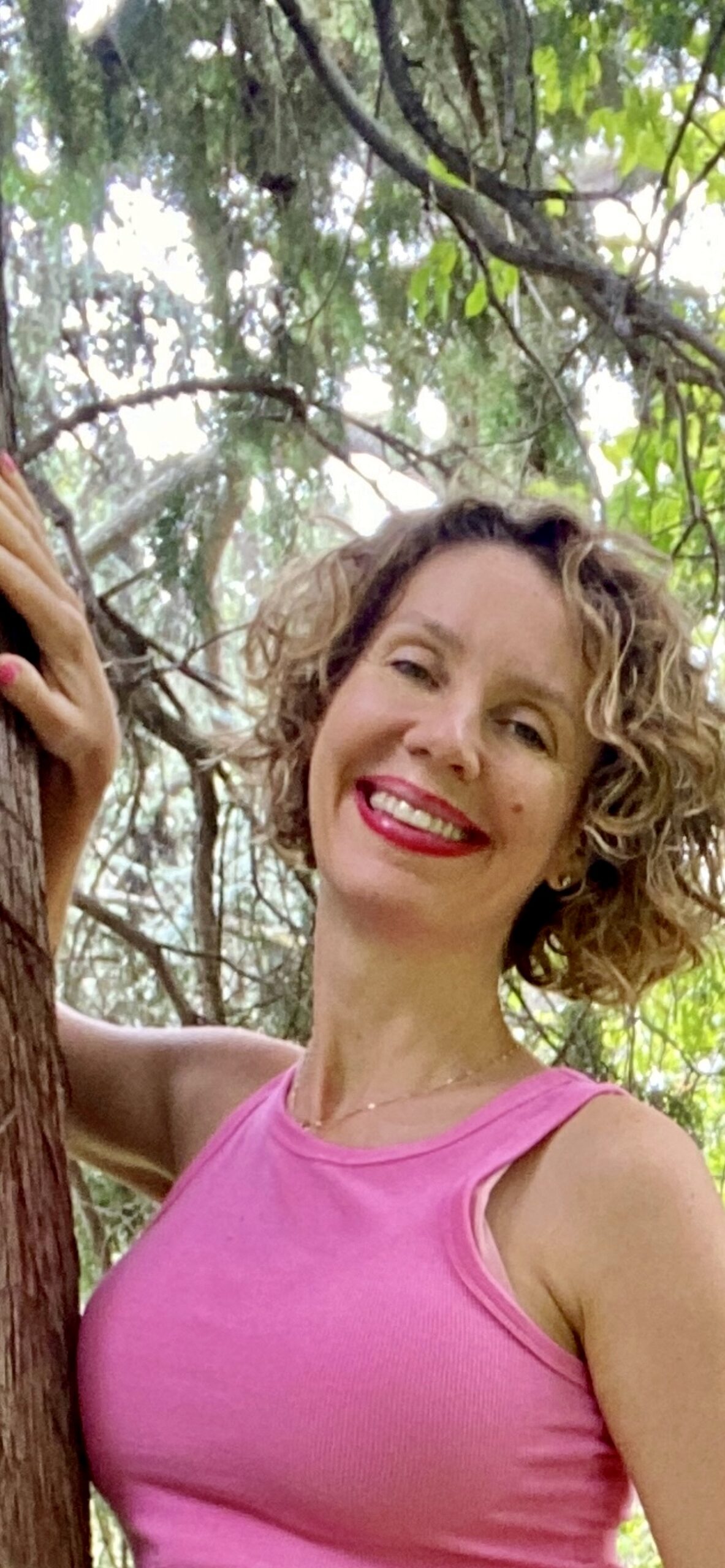 Dr Carolina Diez de rosa con una cara muy sonriente con un fondo de naturaleza